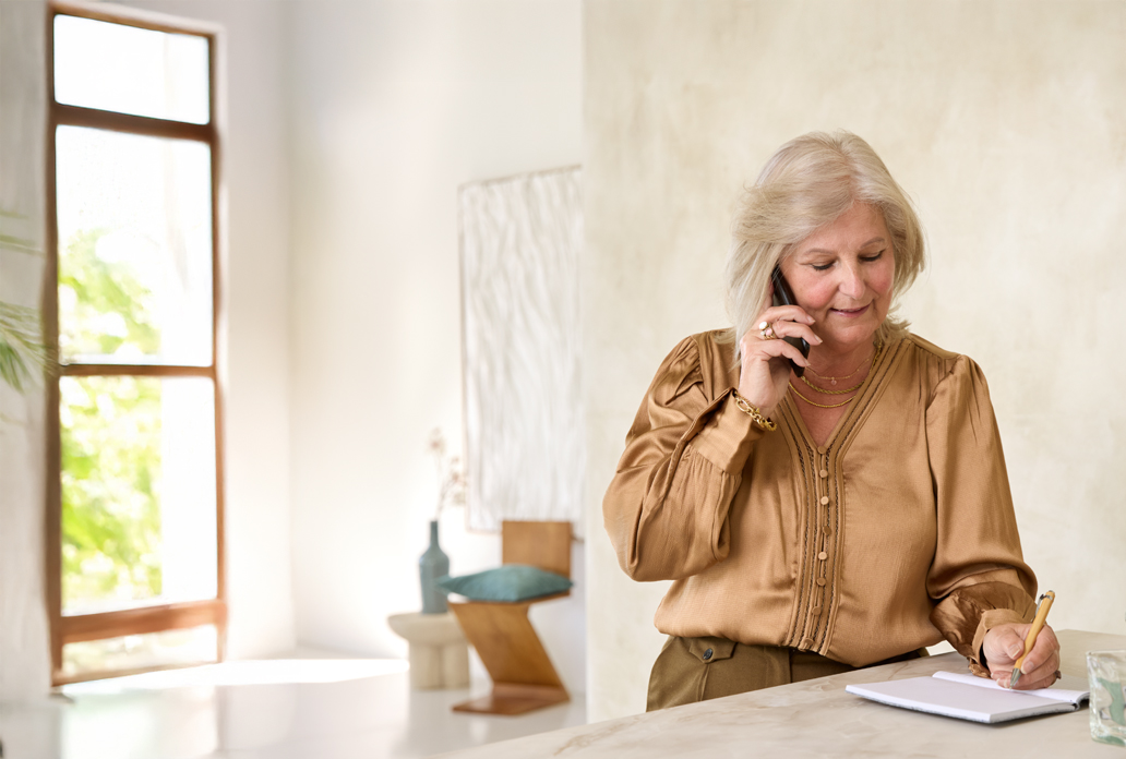 Vrouw belt en maakt aantekeningen tijdens voorbereiding op haar afspraak bij Máxima Nova
